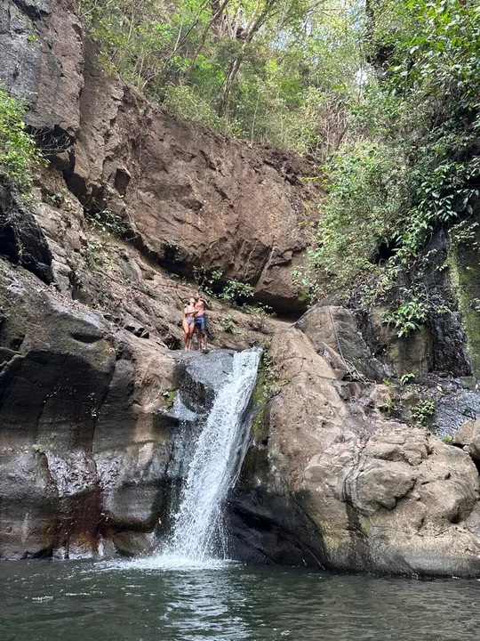 A waterfall falling into a rocky canyon pool on one of our trips